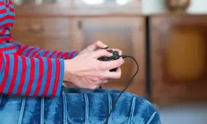 Ręce trzymające kontroler, gotowe do gry. Dowiedz się, jak podłączyć Nintendo do TV i rozpocząć przygodę!