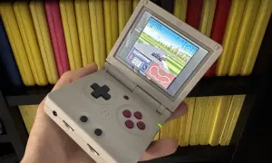 Gra wyścigowa na ekranie konsoli Game Boy Color, trzymanej w dłoni.