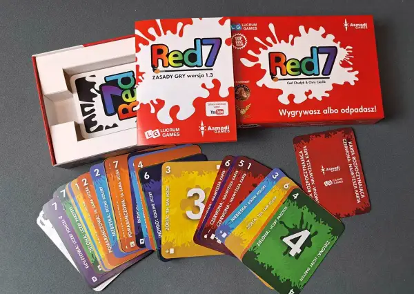 Zestaw gry Red7, zawierający pudełko i rozłożone karty. To dynamiczne gry karciane, gdzie zasady zmieniają się z każdą turą.