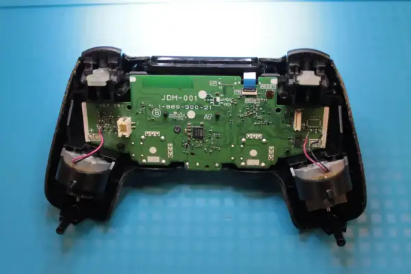 Wnętrze pada PS4 z widoczną płytką drukowaną i elementami. Dowiedz się, jak zresetować pada PS4, gdy napotkasz problemy.