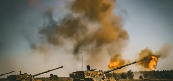 Dwa czołgi strzelają, tworząc kłęby dymu i ognia. Scena wygląda jak ćwiczenia, ale można by pomyśleć o "friendly fire".