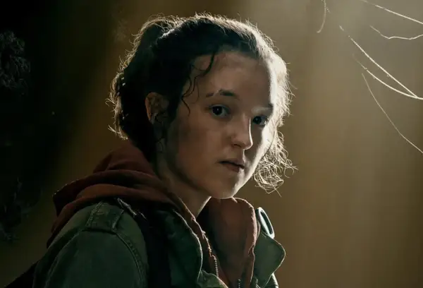 Ellie, z burzą kręconych włosów i determinacją w oczach, w zielonej kurtce i rudym kapturze, gotowa na wyzwania.